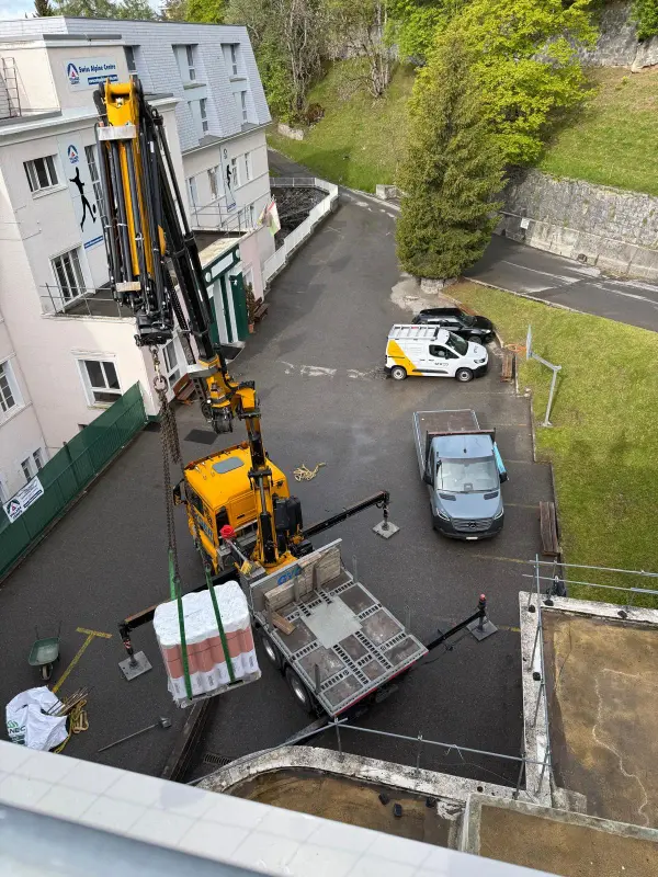 Livraison de matériel d'étanchéité par camion-grue sur un chantier STRED Swiss
